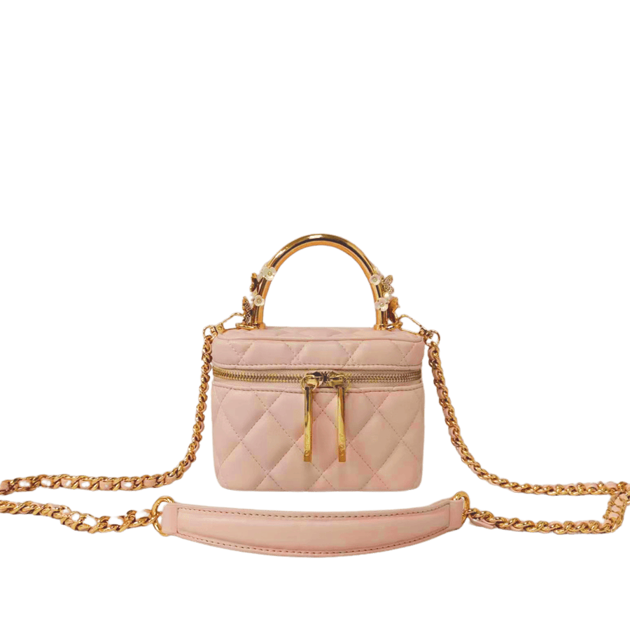 Pink quilting ladies handbag with metal handle and decorative flowers on the handle