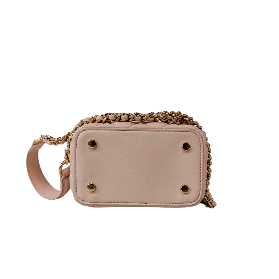 Pink quilting ladies handbag with metal handle and decorative flowers on the handle