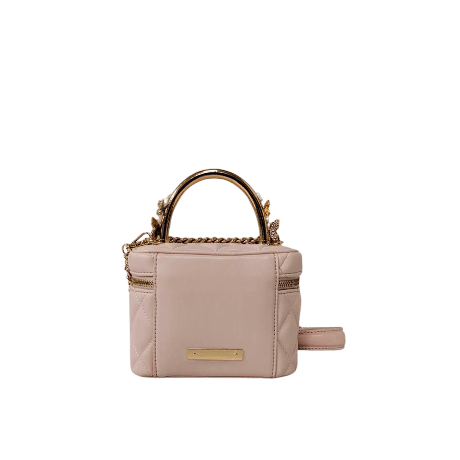 Pink quilting ladies handbag with metal handle and decorative flowers on the handle