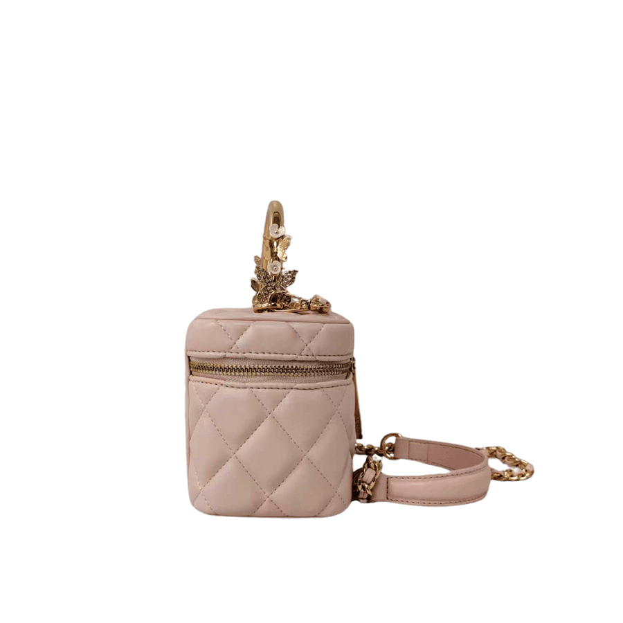 Pink quilting ladies handbag with metal handle and decorative flowers on the handle