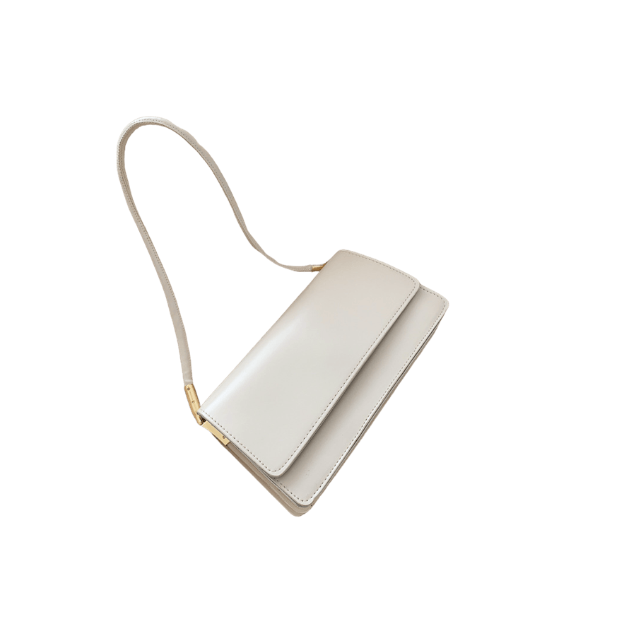 Beige ladies handbag with metal tab of handle and magnetic snap closure