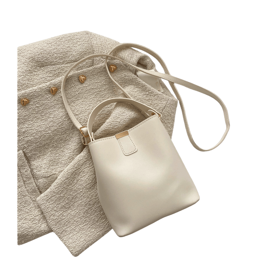 Beige ladies bucket bag with metal edge on the top