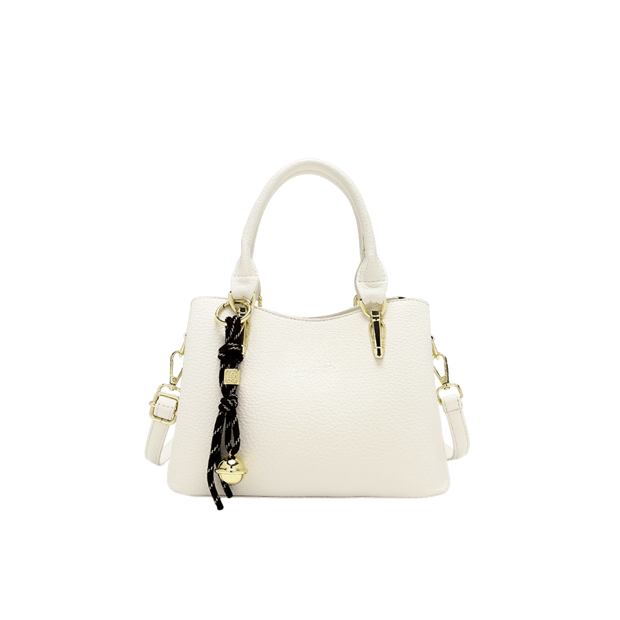 Beige ladies handbag with string hangtag and metal tab of handle