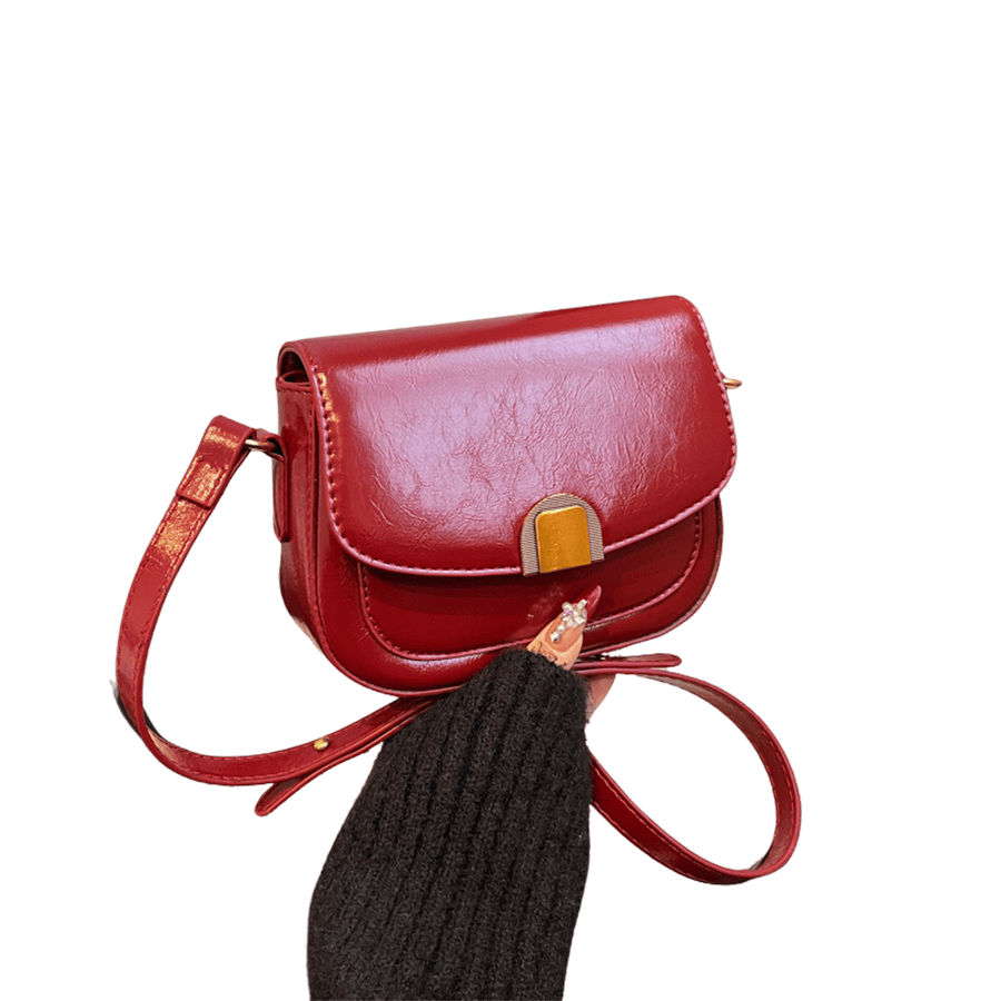 Red ladies crossbody bag with decorative hardware and magnetic snap closure