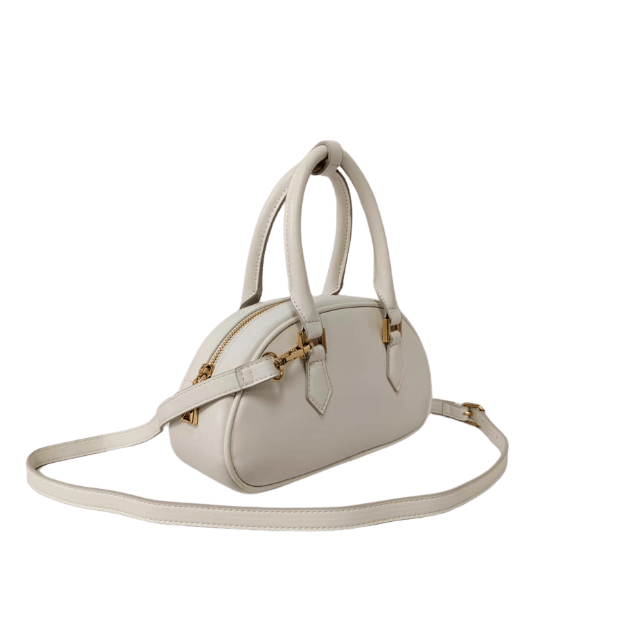 White ladies handbag with metal feets and piping around the body
