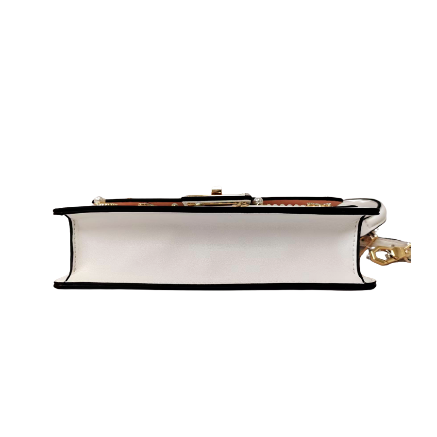 White ladies handbag with decorative accessories and black edge painting
